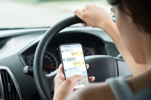 woman texting on phone while driving